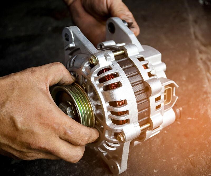 Change new car alternator with hand in the garage or auto repair service center, as background automotive concept. Dark tone.
