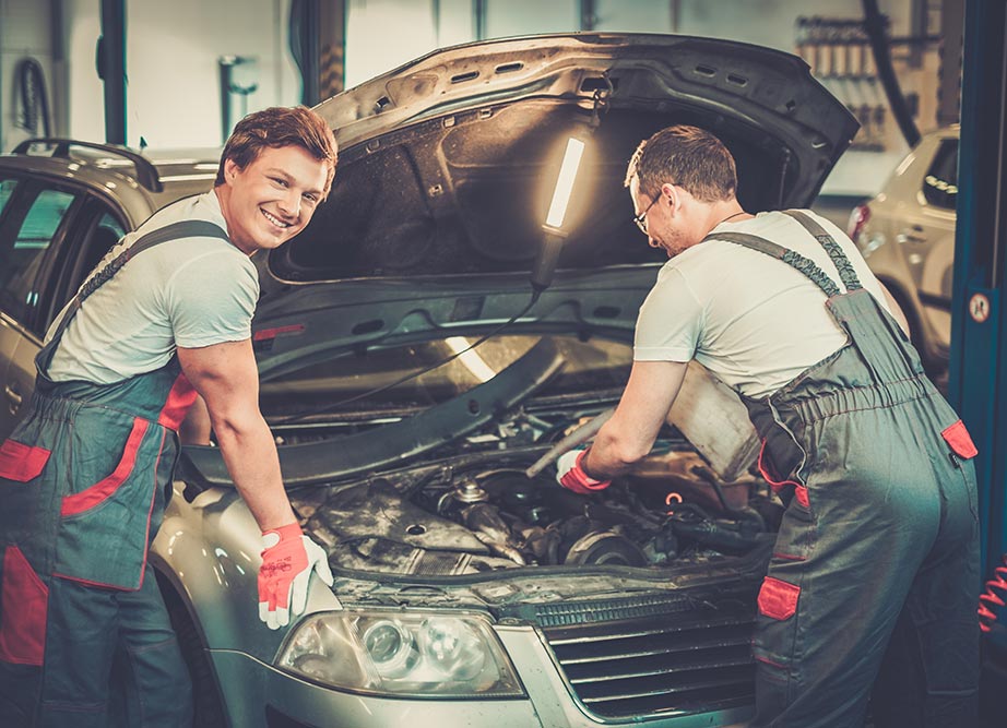 Two mechanics fixing car in a workshop