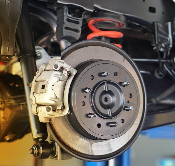Disc brake of the vehicle for repair, in process of new tire replacement. Car brake repairing in garage. Close up.